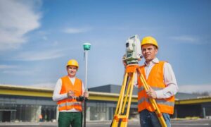 Surveyors using a total station and GNSS equipment for a commercial property survey, relevant to an ALTA survey or boundary survey