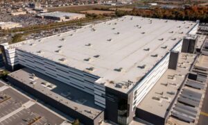 Aerial view of a large warehouse property with parking areas, loading spaces, roads, and surrounding development for an ALTA survey with Table A requirements